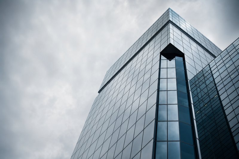 Gläserne Fassade einer modernen Konzernzentrale aus der Froschperspektive